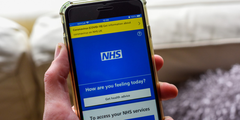 Picture of a person holding a mobile showing the NHS APP